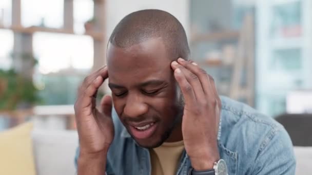 头疼和黑色男人在沙发上与寺庙按摩脑雾在他的家 偏头痛和非洲男性对眩晕 焦虑或精神健康 焦虑或客厅危机感到沮丧 — 图库视频影像