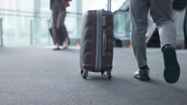 İş adamı, ayak ve bavulla havaalanında yürüyüş. Toplantı, konferans ya da iş seyahati için seyahat. Hareket, bavul ve ayakkabılar yürüyen merdivende ya da uçuş terminalinde ya da lobide.