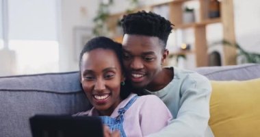 Tablet, siyah çift ve evde mutlu, oturma odasındaki kanepede konuşup kaynaşıyorlar. Afrikalı erkek, kadın ve teknoloji, gülümseme ve canlı film, video veya film, sosyal medya ve İnternet üzerinden online alışveriş.