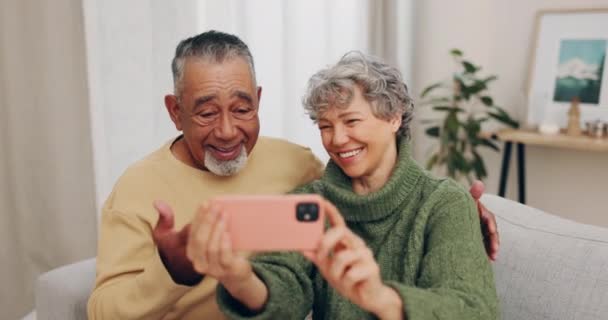 ソーシャルメディアのホームソファーでシニアカップル 愛と幸せなセルフィー プロフィール写真 コミットメント 結婚と退職後の幸せの記憶のためのリビングルームにいる異人種間の男女 — ストック動画