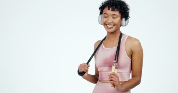 快乐的女人带着耳机在白色的背景上锻炼 训练和锻炼 在演播室里听音乐 广播和音频的人的健康 运动和肖像 供跳过 — 图库视频影像