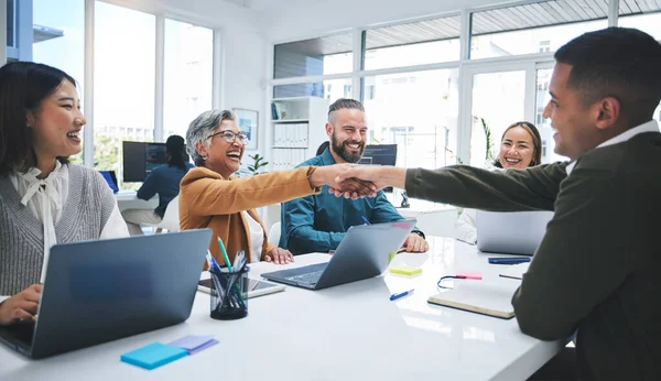 Creative people, handshake and meeting in hiring, partnership or deal agreement together at the office. Group of employees shaking hands in recruiting, company growth or startup at the workplace.