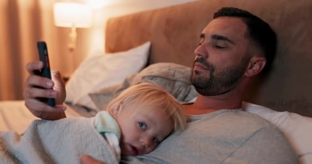 男人和婴儿晚上在床上休息 作为一个爱 信任或沟通的家庭在一起 睡眠和父亲和儿子在卧室里用手机阅读社交媒体 — 图库视频影像