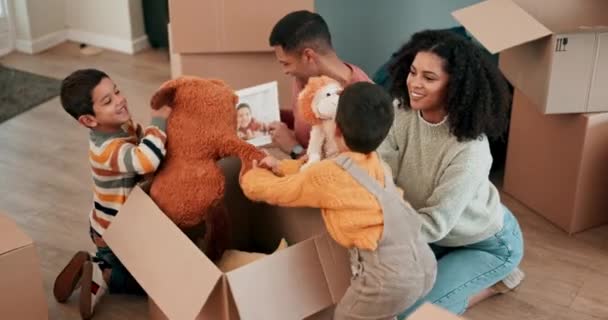 玩具和父母与他们的孩子与纸板箱在他们的新家粘合在一起 年轻人在一个现代化的房子里和他们的男孩玩玩具熊 — 图库视频影像