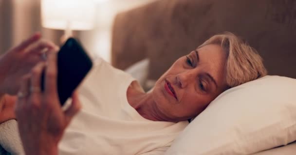 应用程序和一个女人与手机在床上社交媒体 聊天或上网 网站和老年人在手机上打字 以便在卧室里联系 沟通或通知 — 图库视频影像