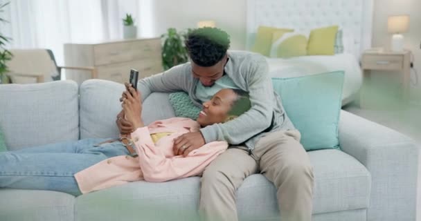 ソーシャルメディアやコミュニケーションのためにソファーに電話をかける リラックス 黒人のカップル ハッピー 一緒に アフリカの男女と家庭のソファーにアプリや接続のためのモバイル — ストック動画