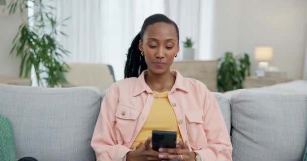 コミュニケーション チャット または会話のためのソファーの電話を持つリラックス ワオと黒人の女性 スマイル サプライズ アフリカの女の子 家でアプリやソーシャルメディアの通知のためのモバイル — ストック動画