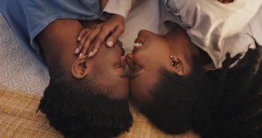 Siyahi çift Afrika 'da birlikte yatıp öpüşüyor, samimi bir destek veriyor, kaynaşıyor ve evleniyorlar. Romantizm, erkek ve kadın yatak odasında rahatlayın. Yukarıdan şefkat, güven ve sabah bakımıyla kucaklaşın.