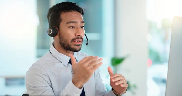 Call center agent consulting a buyer via video call in an office. A young friendly sales man talking to a client in a virtual meeting. A male customer service employee advising a consumer.