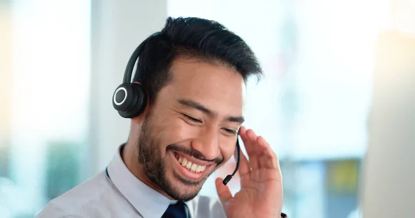 Call center agent consulting a buyer via video call in an office. A young friendly sales man talking to a client in a virtual meeting. A male customer service employee advising a consumer.