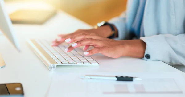 Closeup of a womans hands typing on a keyboard while sitting at a desk and sending an email in an office. Financial advisor doing online research for a budget plan and communicating with clients.