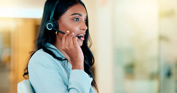 Professional and helpful call centre woman using a headset, assists business consult. Helpful support service agent talks with client on call. Remote worker gives client advice telephonically.