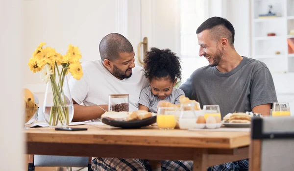 Smile, gay men and family at breakfast together in the dining room of their modern house. Happy, bonding and girl child eating a healthy meal for lunch or brunch with her lgbtq dads at home