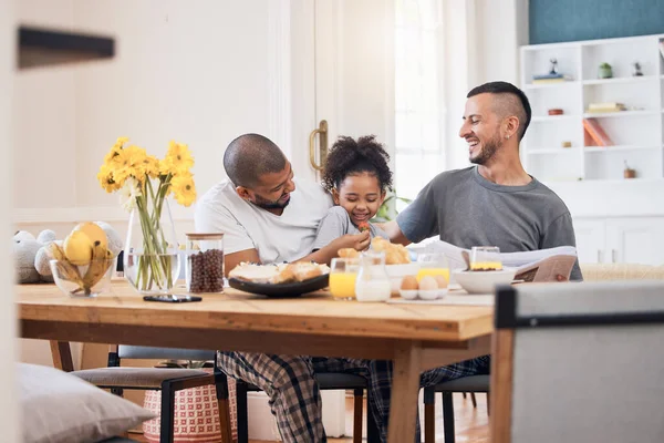 Laugh, gay men and family at breakfast together in the dining room of their modern house. Smile, happy and girl child bonding and eating a healthy meal for lunch or brunch with her lgbtq dads at home.