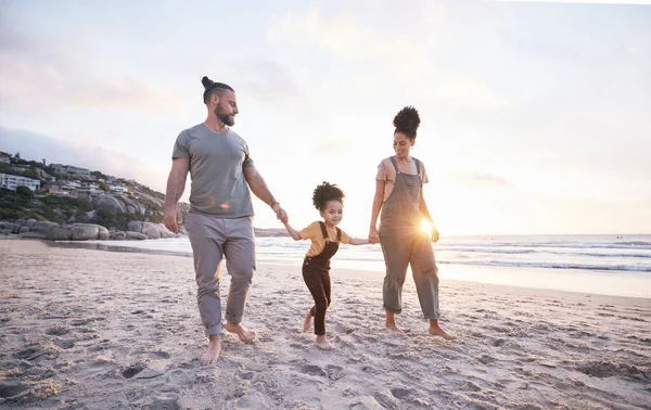 Holding hands, family and walk on beach at sunset, bonding and mockup space. Father, mother and happy kid at ocean in interracial care, love or smile on vacation, holiday or summer travel together.