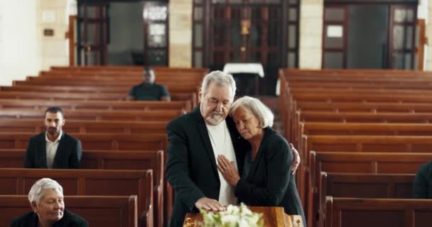 在追悼会上 教堂和情侣们抱着棺材告别 哀悼和哀悼 悲伤的家庭和男人在教堂里一个接一个地拥抱女人 为死亡而问候 失去和埋葬 — 图库视频影像