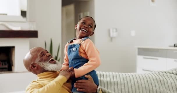 おじいちゃん 女の子はソファーでボンディング 関係を笑い リビングルームでリラックスします アフリカの家族 ハッピーと家で子供を持つ祖父 抱擁のためのソファで楽しんでいます カドルと愛 — ストック動画