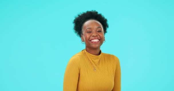ハッピー 黒人女性 ウィンク 絵文字 またはスタジオの青い背景でゴシップや楽しいための秘密のシグナルと顔 アフリカ人 肖像画と遊び心のある笑顔 フラットまたは楽しい表情の人 — ストック動画
