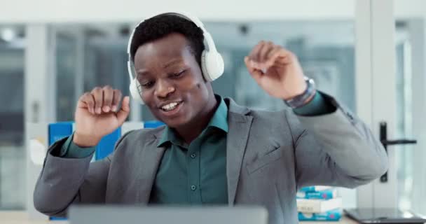 ビジネスマンは 勝つためにオフィスの音楽ヘッドフォンで成功とラップトップを祝います アフリカの起業家の人物ストリーミングまたは達成 幸せなダンスのための技術でサウンドを聞く — ストック動画