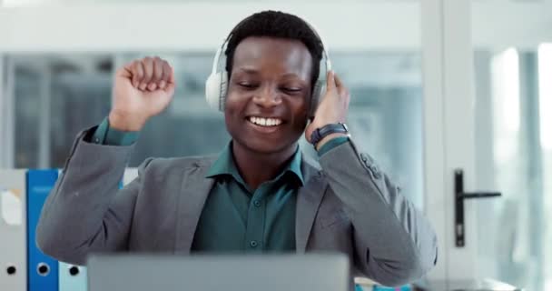 成功に満足しながら オフィスの音楽ヘッドフォンで祝い ビジネスマンとラップトップ アフリカの起業家の人々 ストリーミングまたは達成のためのサウンドを聞く インターネットの勝利やオンラインボーナス — ストック動画