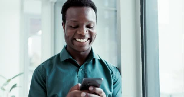 微笑和一个在办公室里笑着的黑人商人在看短信或社交媒体上的帖子 沟通和一个年轻员工在工作时看着手机上的迷因 — 图库视频影像