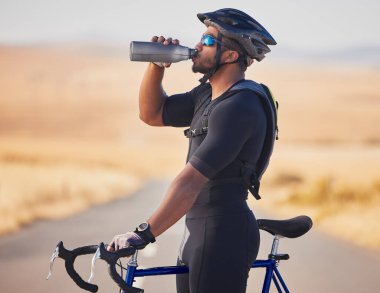 Fitness, doğa ve insan bisikleti yarışlarında içme suyu, maraton ya da yarışma eğitiminde. Spor, spor ve susamış erkek sporcu. Bisikletli açık hava kardiyo egzersizi..