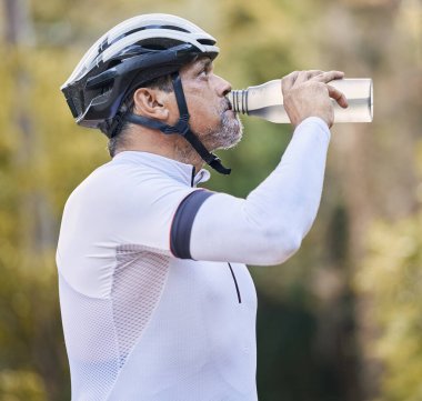 Bisiklet, fitness ve yaşlı adam, doğadaki eğitim sırasında su içmek için parkta su içiyorlar. Elektroliti olan şişe, susamış ve yaşlı sporcu kırılır ya da ormanda spor sıvısı alınır..