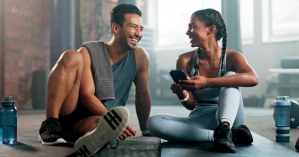 健身和人们在健身房快乐的训练或运动应用在互联网上 亚洲男人和印度女人或锻炼朋友用智能手机有趣的迷因或与私人教练的交流 — 图库视频影像