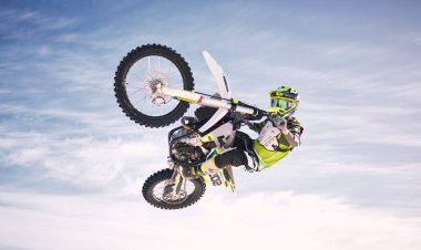 Gökyüzü, atlama ve off-road motorsikletli adam doğada antrenman, eğitim ve ekstrem spor enerjisi için. Profesyonel toprak bisiklet yarışı yarışması, bulutların içindeki kişi ve motosiklet yarışmasında tehlike.