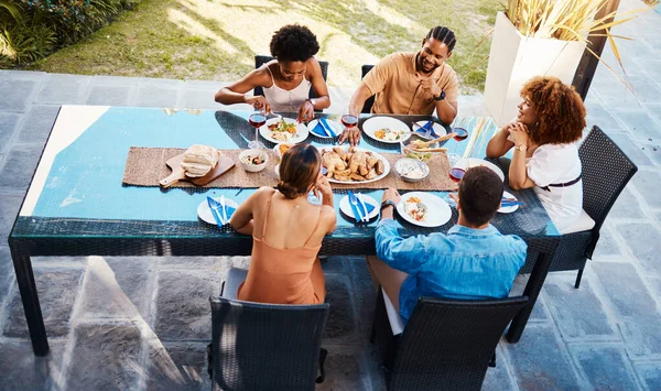 Food, top and friends in house backyard to relax on holiday celebration or vacation in summer together. Party, home or happy people eating to bond at table in conversation for lunch or brunch meal.