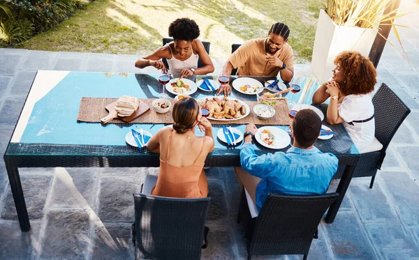 Food, top and people in house backyard to relax on holiday celebration or vacation in summer together. Party, home or happy friends eating to bond at table in conversation for lunch or brunch meal.