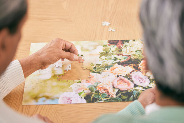 Puzzle on table, entertainment and senior couple in home for bonding, fun activity and relax together. Retirement, marriage and above of man and woman with jigsaw for playing games, hobby and connect.