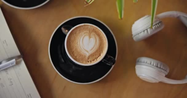 Kawa Notatnik Słuchawki Stole Widok Góry Śniadanie Cappuccino Drink Matcha — Wideo stockowe