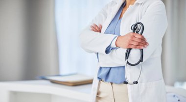 Healthcare, hands and woman doctor with arms crossed in hospital with stethoscope for medical examination. Health, checkup and female in a consulting room with lungs, heart or breathing analysis tool. clipart