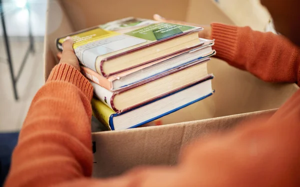 女性は 自宅で非営利およびボール紙の容器のための本を箱に入れて手に入れます 教育教科書 コミュニティサポートのための春の清掃 — ストック写真