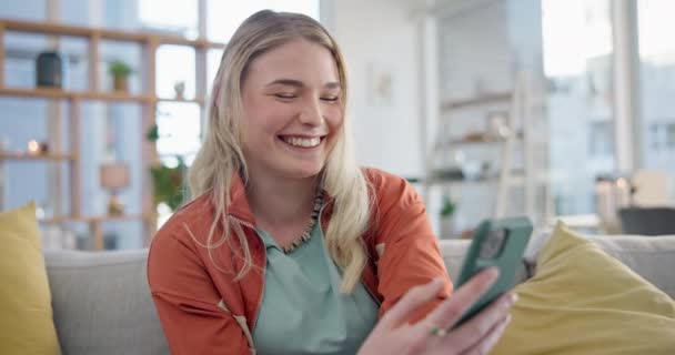 智能手机打字 在沙发上大笑 阅读社交媒体和应用程序 快乐女孩的脸在手机上翻来覆去寻找有趣的迷因 下载手机游戏 在客厅里搜索网络 — 图库视频影像