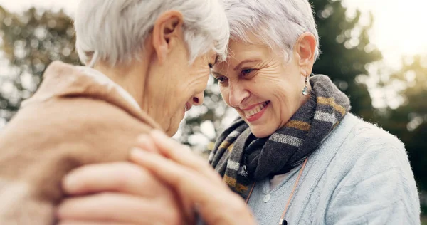 Love, connection and senior women being affection for romance and bonding on an outdoor date. Nature, commitment and elderly female couple in retirement with intimate moment in a green garden or park.