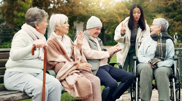 Friends, happy and senior people in park for bonding, conversation and quality time together outdoors. Friendship, retirement and elderly man and women with caregiver on bench for relaxing in nature.