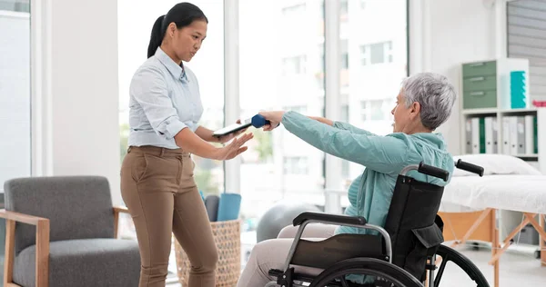 Woman with disability, physiotherapy and dumbbell exercise for healthcare assessment, test or digital checklist of medical progress. Physiotherapist, tablet or consulting senior patient in wheelchair.