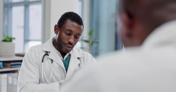 または黒人の男性は 診断または治療計画のための病院で医師に相談しています 医療検査のスケジュール情報を確認する専門家とのノート アドバイスまたはアフリカの患者 — ストック動画
