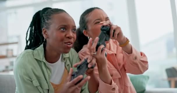 リビングルームでオンライン 仮想およびデジタルゲームをプレイするソファ上の友人 ビデオゲームと女性 自宅で一緒にボンディングしたり リラックスしたり楽しんだりするためのコントローラーを持つ競争 ゲーム 興奮する人々 — ストック動画