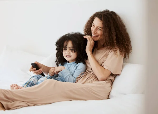 Bedroom, happy family child and mother watching tv series, movie or streaming online video, cinema or entertainment. Home bed, kids and relax woman, mom or mama watch cartoon show, television or film.