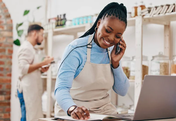 Black woman, cashier and phone call with networking and inventory check for retail store. Happy, shop management and mobile with communication and discussion about small business and supply chain.