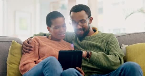タブレット付きのソファーでインターネット カップル 一緒に自宅でハグや会話 ストリーミング サブスクリプション ソーシャルメディアのためのオンラインリビングルームに男性と愛 チャット 黒人女性 — ストック動画