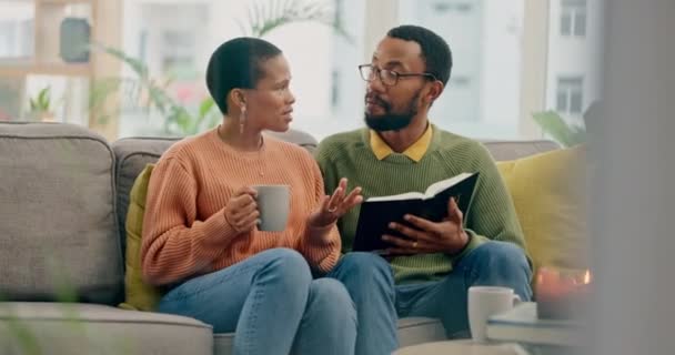 コーヒー 聖書研究 議論のためのソファーで黒いカップルとリラックスしてください キリスト教 宗教のための自宅のリビングルームで男と女性との学習 聖書と紅茶 — ストック動画
