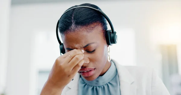 Black woman, call center and headache in stress, burnout or anxiety from strain at the office. African American female consultant suffering head pain, ache or sore eyes feeling overworked or stressed.