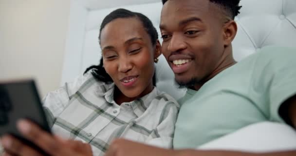 在社交媒体或移动应用程序上 快乐和黑色的夫妻在床上联姻 粘合在一起 年轻的非洲男人和女人在卧室里用手机上网 — 图库视频影像