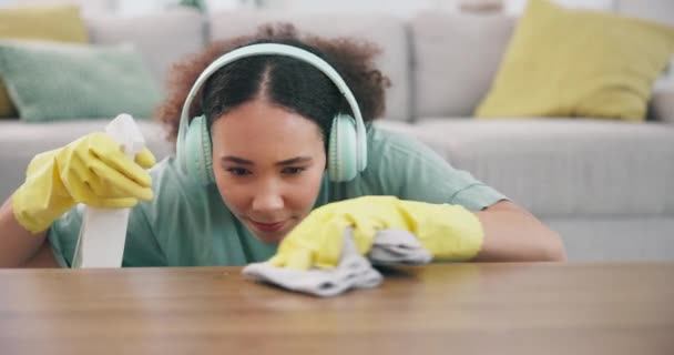 가정용 헤드폰 여성은 집에서 장갑으로 테이블을 닦습니다 먼지를위한 가구를 청소하는 — 비디오