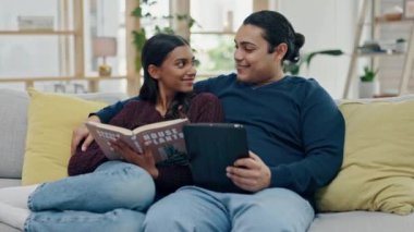 Çift, tablet ve ev kanepesinde kitap okumak arama, internet ve bilgi için ya da rahatlamak için. Mutlu erkek ve kadın birlikte kanepede teknoloji ve roman ile eğlence, öğrenme veya bağlantı için.