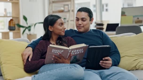 Ζευγάρι Διαβάζοντας Ένα Βιβλίο Και Tablet Έναν Καναπέ Στο Σπίτι — Αρχείο Βίντεο